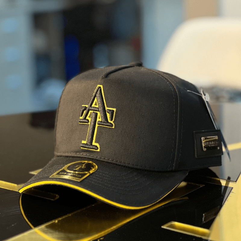 Gorra negra en drill AT con visera reborde dorado